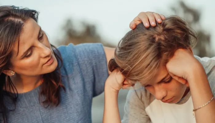 A mom consoling her young son.