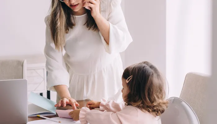 A mom trying to do work alongside her little daughter.
