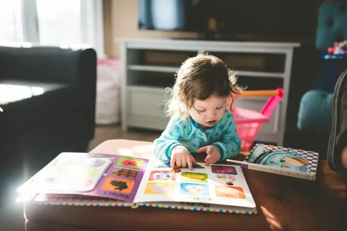 Little girl reading an activity book