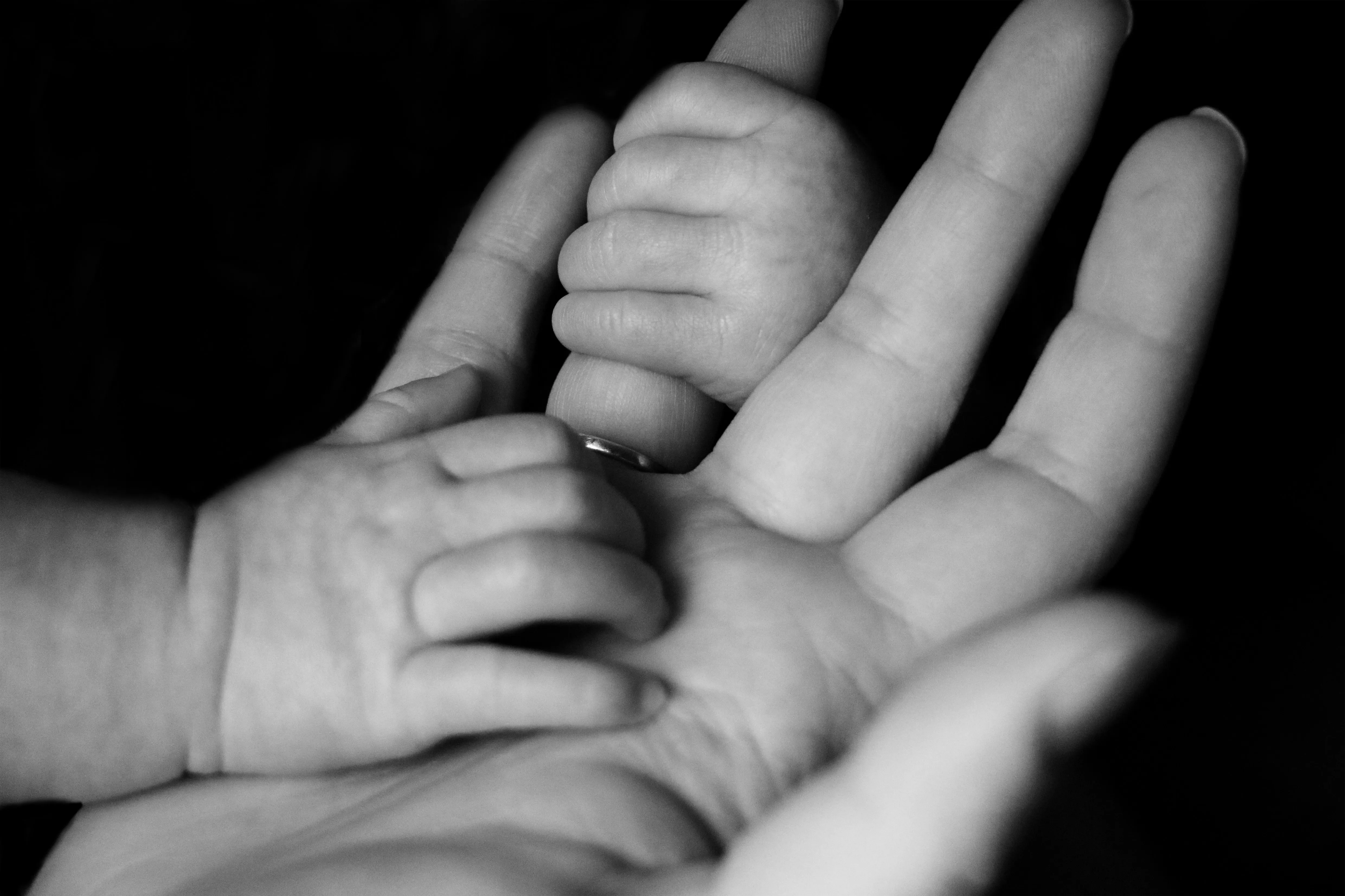 baby holding fathers finger and hand