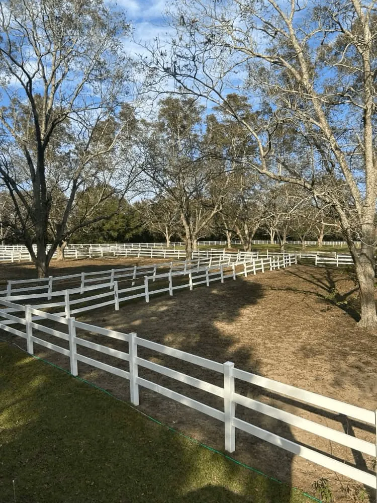 <alt=“After wood fence pressure washing in Dawes Alabama showing clean white ranch fence with restored color and surface.”>