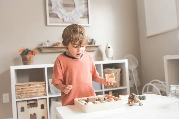 little boy overwhelmed with his toys