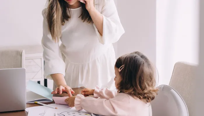 A mom helping her young daughter.