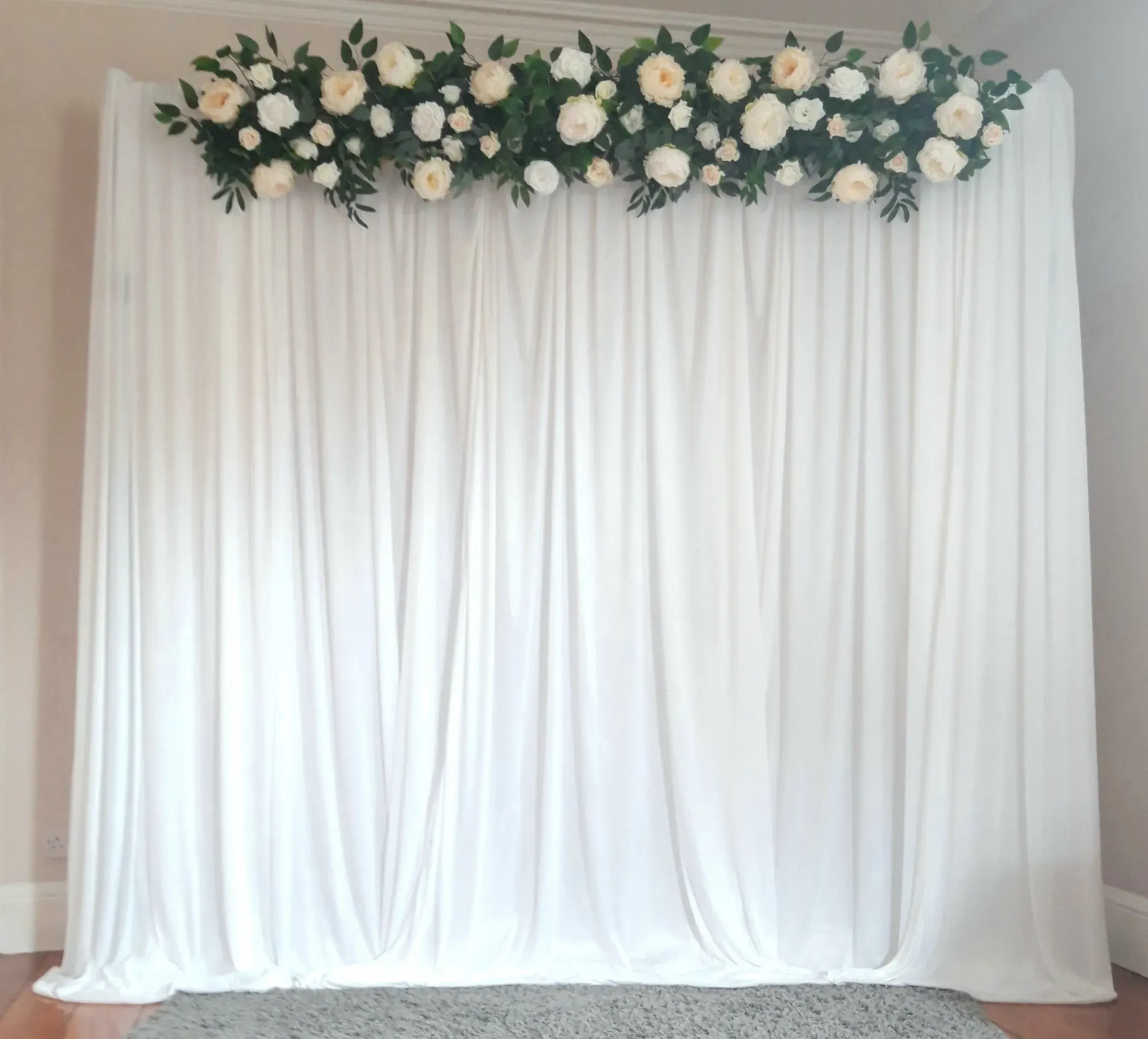 white silk drapes with handmade floral valance of white and champagne roses