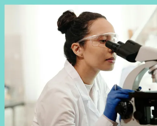 Woman looking into a telescope inside the DNA testing labratory looking at DNA Specimens to find out test results