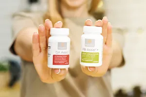 Blond woman holding a bottle of PB Assist and GX Assist