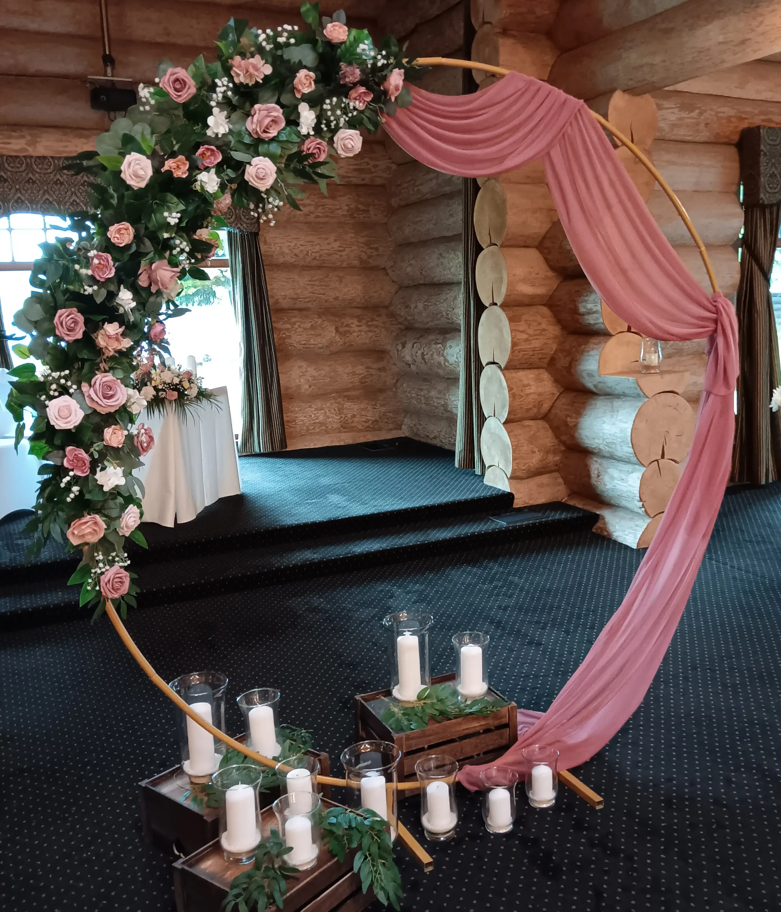 wedding moongate arch decorated with dusty pink flowers and chiffon swag and candles