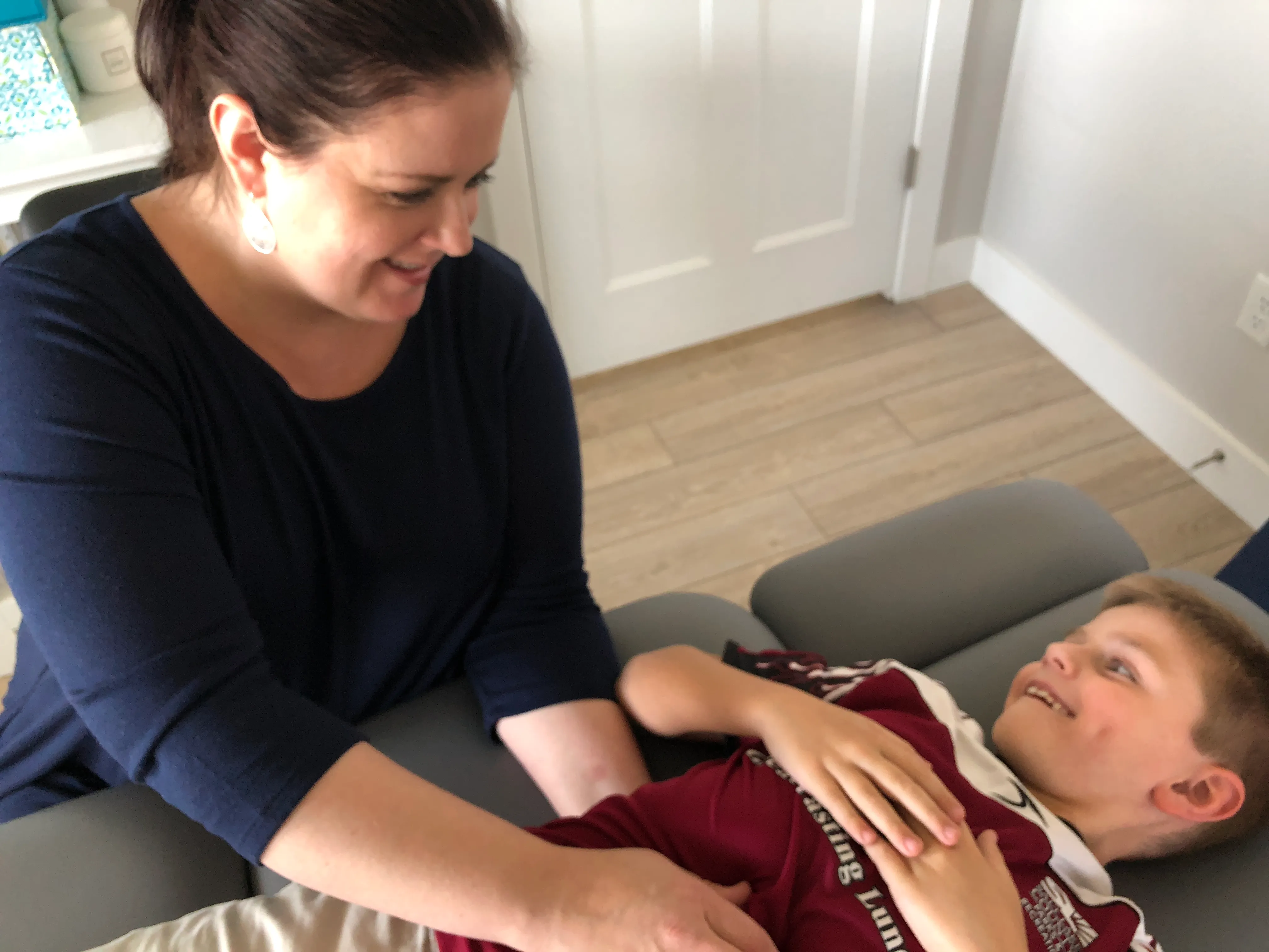 Therapist using osteopathic manual medicine to treat a child.