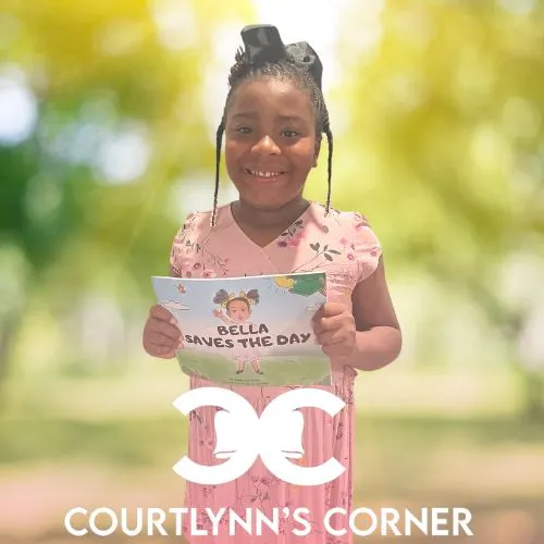 Courtlynn holding her creative books and T-shirts for Own Drum