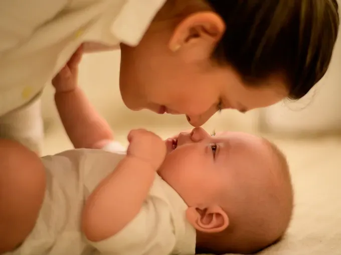 baby playing with mom