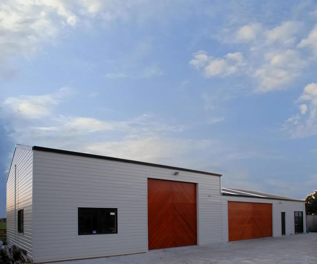 Large White Commercial Building With Two Stained Wood Panneled Garage Doors 
