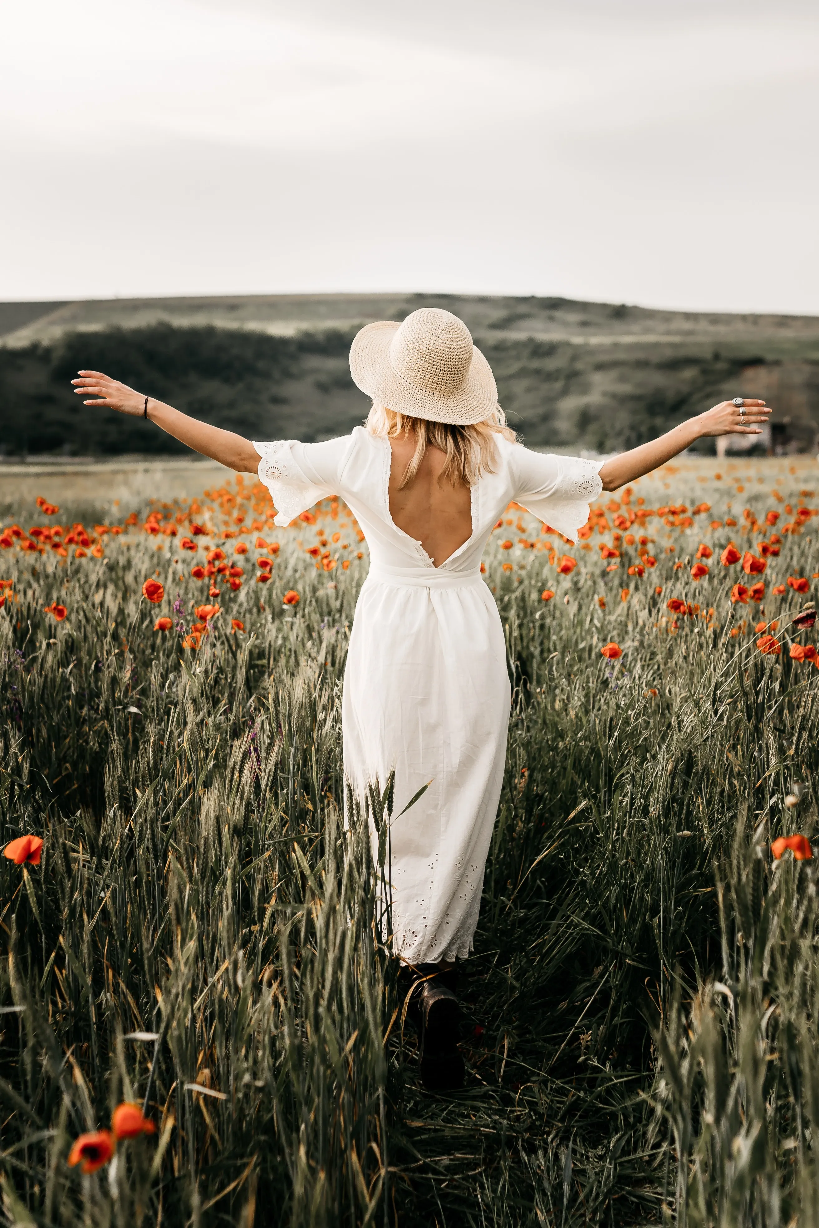 woman with arms out stretched in a field of flowers