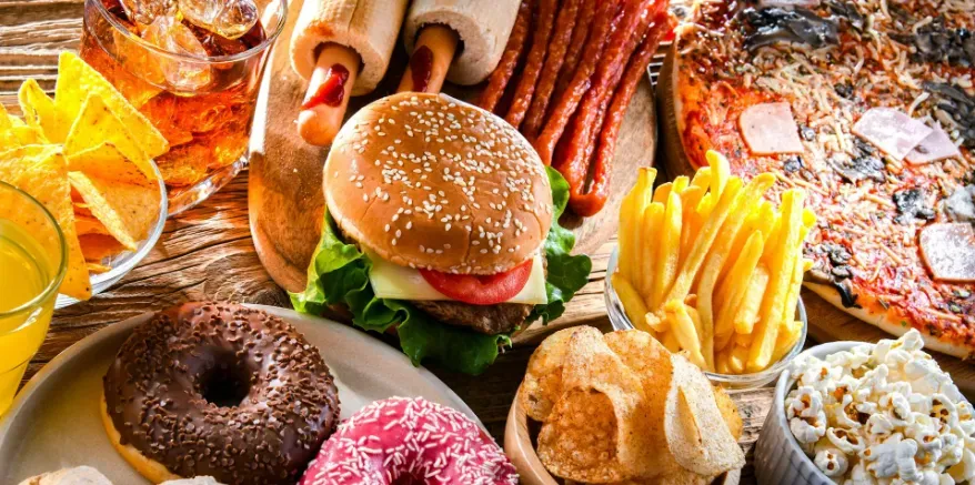 Array of high-calorie processed foods on a kitchen table.