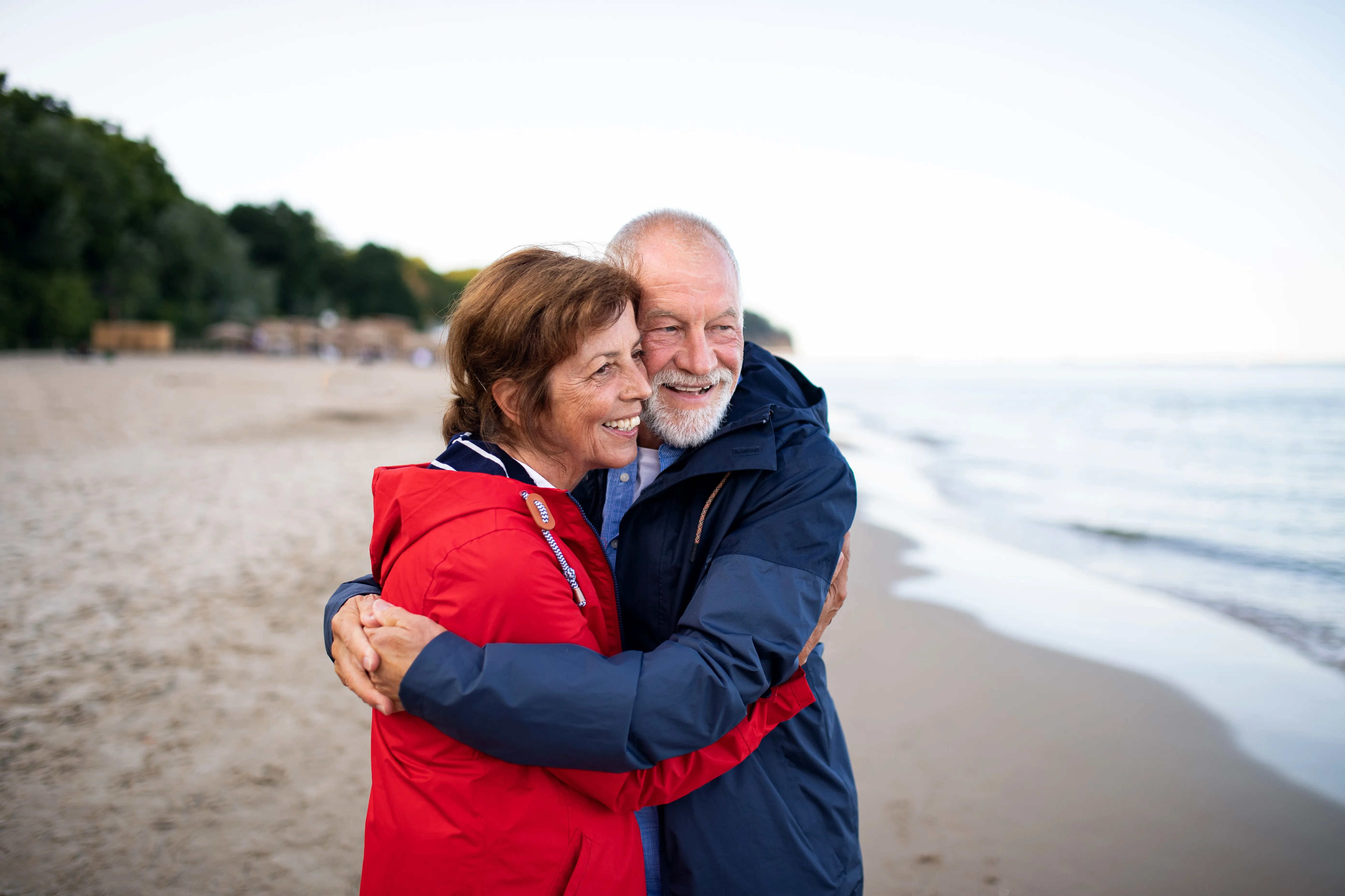 happy couple hugging on beach