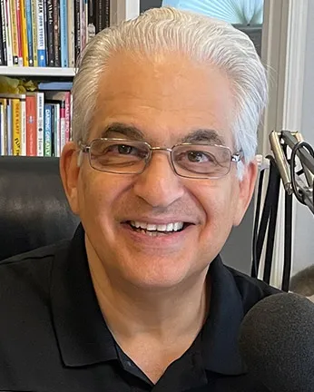 Bob Burg with white hair and black glasses, smiling