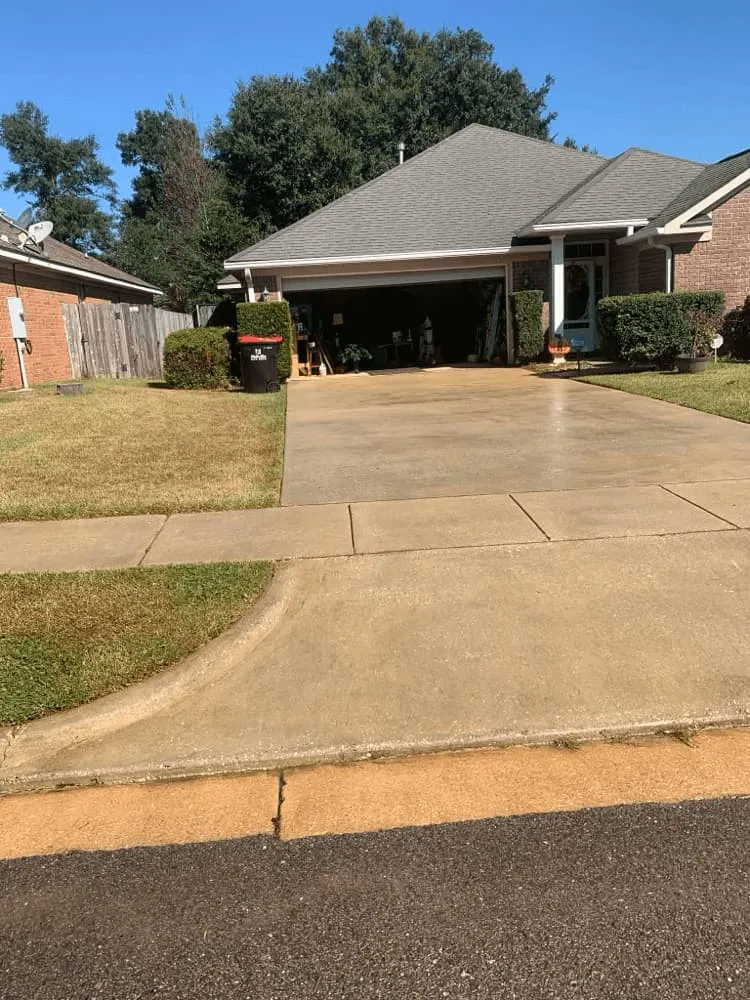 <alt=“After driveway pressure washing in Dawes, Mobile County, Alabama showing fully cleaned bright concrete driveway with restored appearance and curb appeal.”>