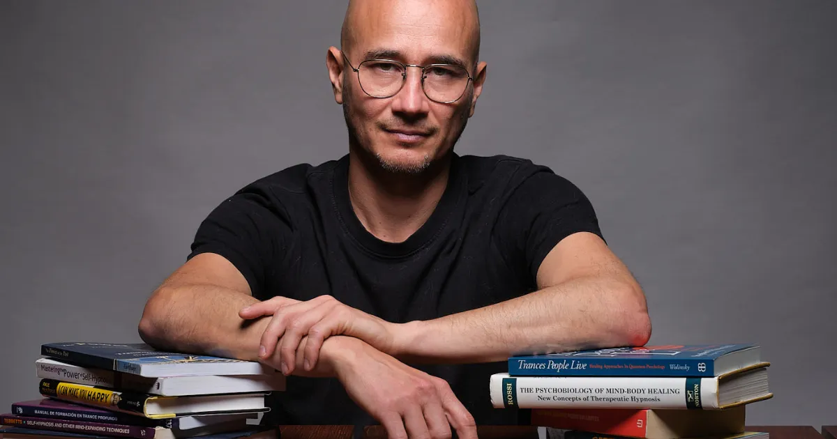 César Sandoval con libros sobre la mesa