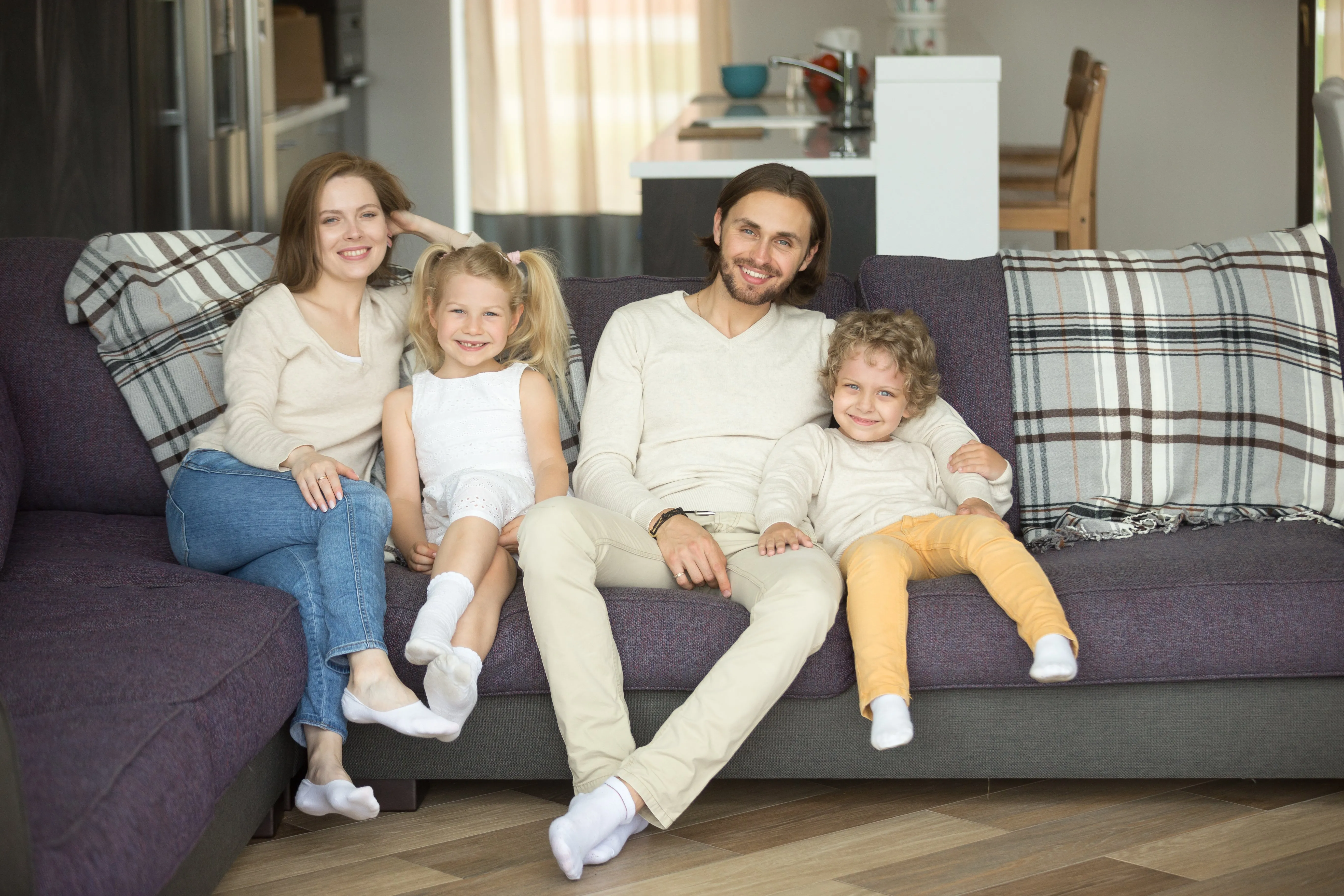 family-sitting-on-cleaned-couch-by-Maxigard