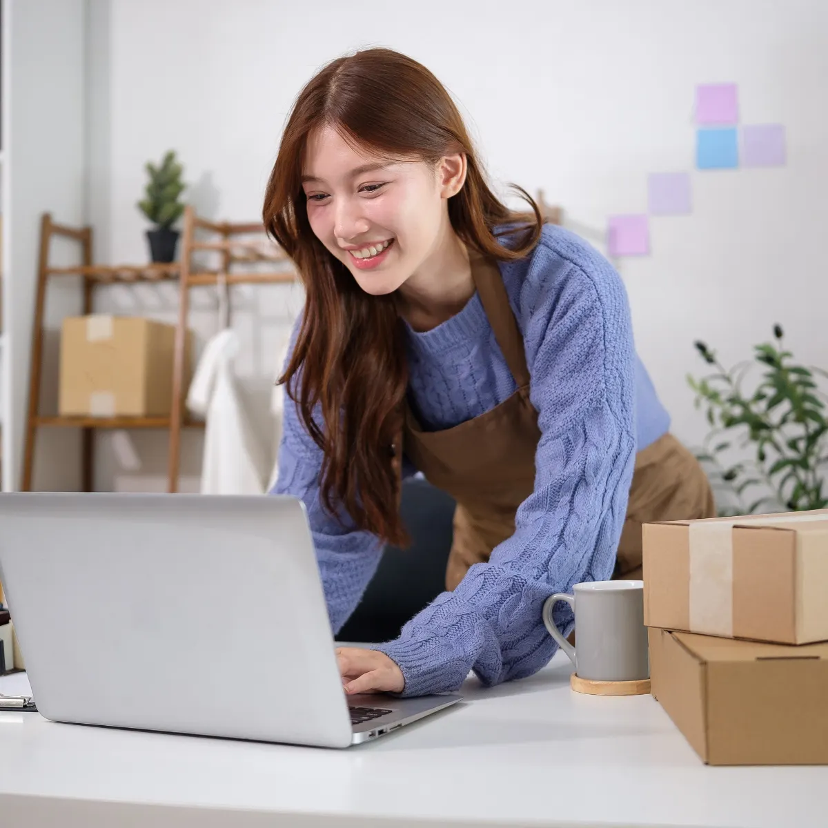 Female business owner smiling while looking at her laptop