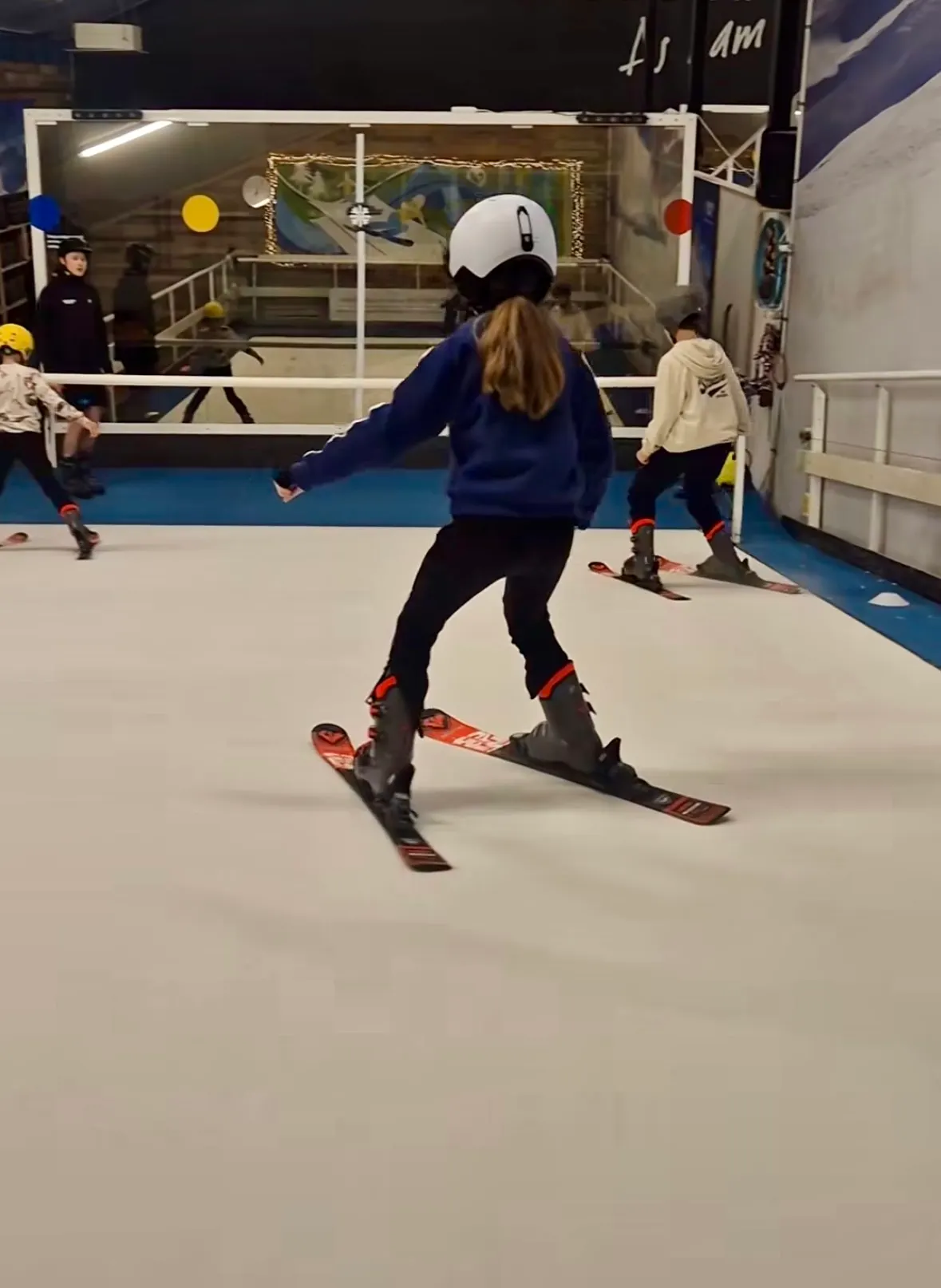 Skileraar met kinderen aan het skiën op de skibaan in Deurningen