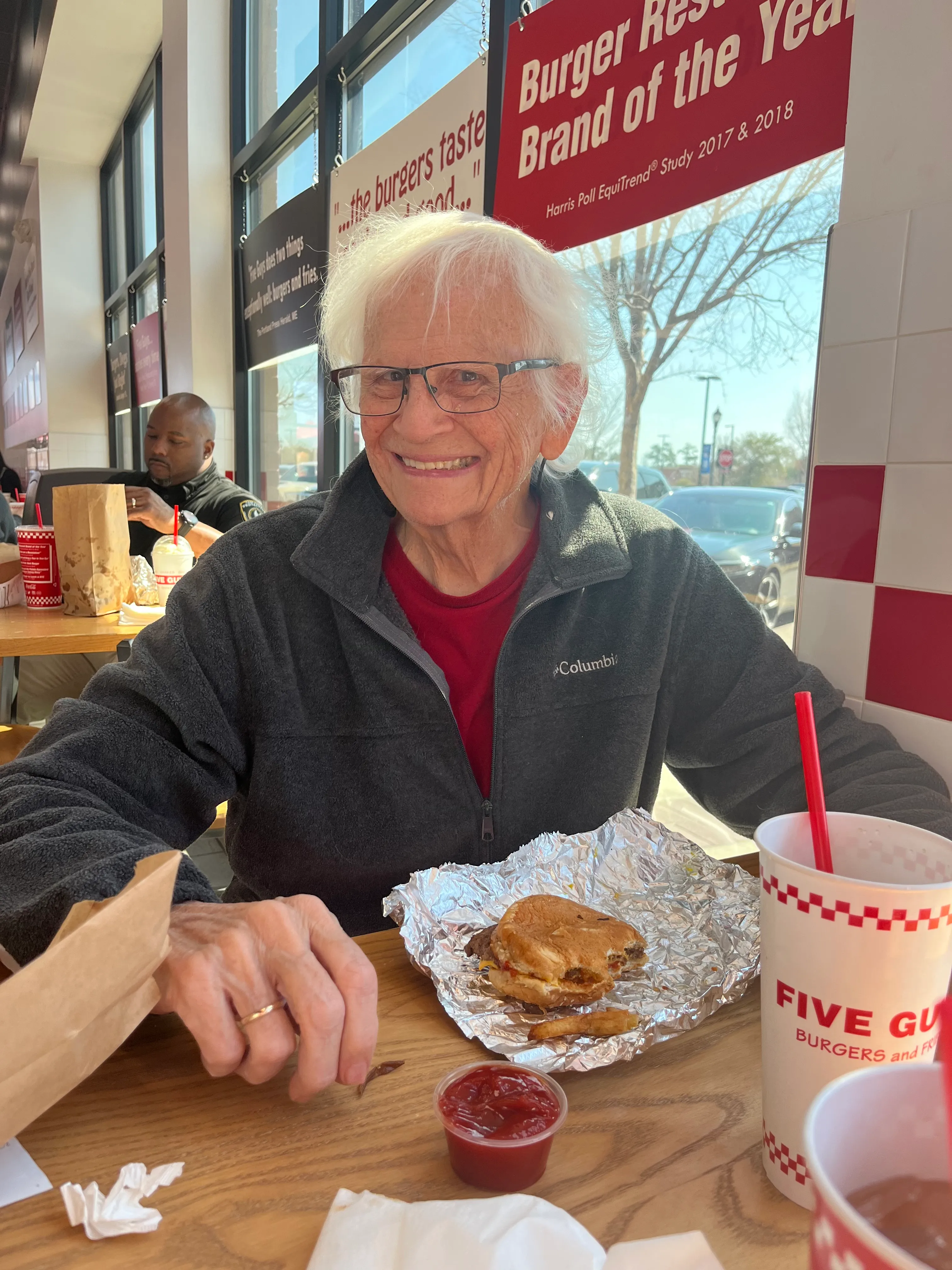 Senior man sitting in Five Guys with an awesome cheesburger!