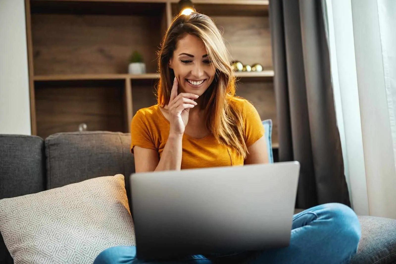 mujer-psicologa-sonriendo-usando-su-computadora-mientras-esta-sentada-en-su-sala-viendo-psyconectate