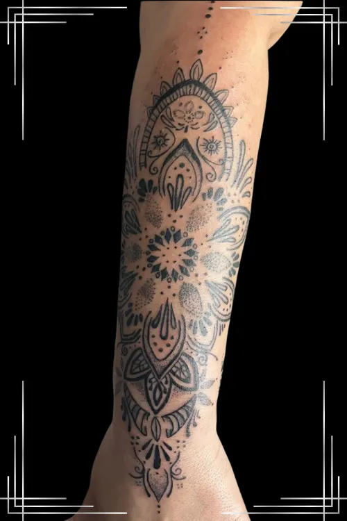 Imagen tatuaje de realismo deun felino sujetando en la boca la cara de una mujer