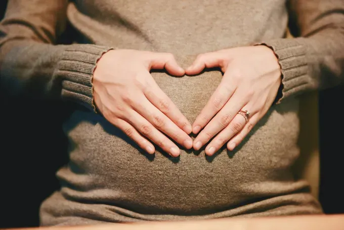 Close-up of a pregnant woman’s belly, showcasing the beautiful roundness of the baby bump.