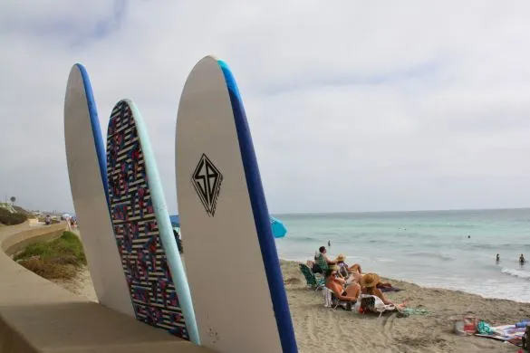 View looking over three longboards toward beach in Carlsbad, California.