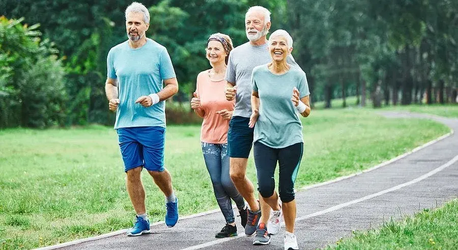 An energetic scene of older adults joyfully participating in various physical activities like walking, yoga, and cycling.