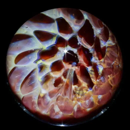 up close image of a glass marble being formed by a torch