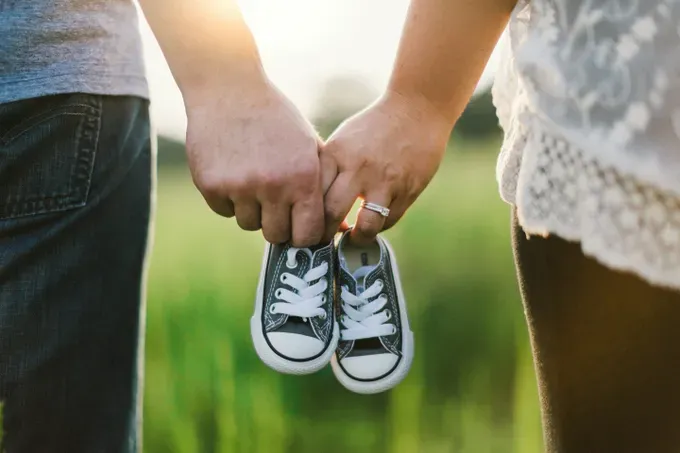 Expecting couple looking at an ultrasound image on a screen, smiling with anticipation.