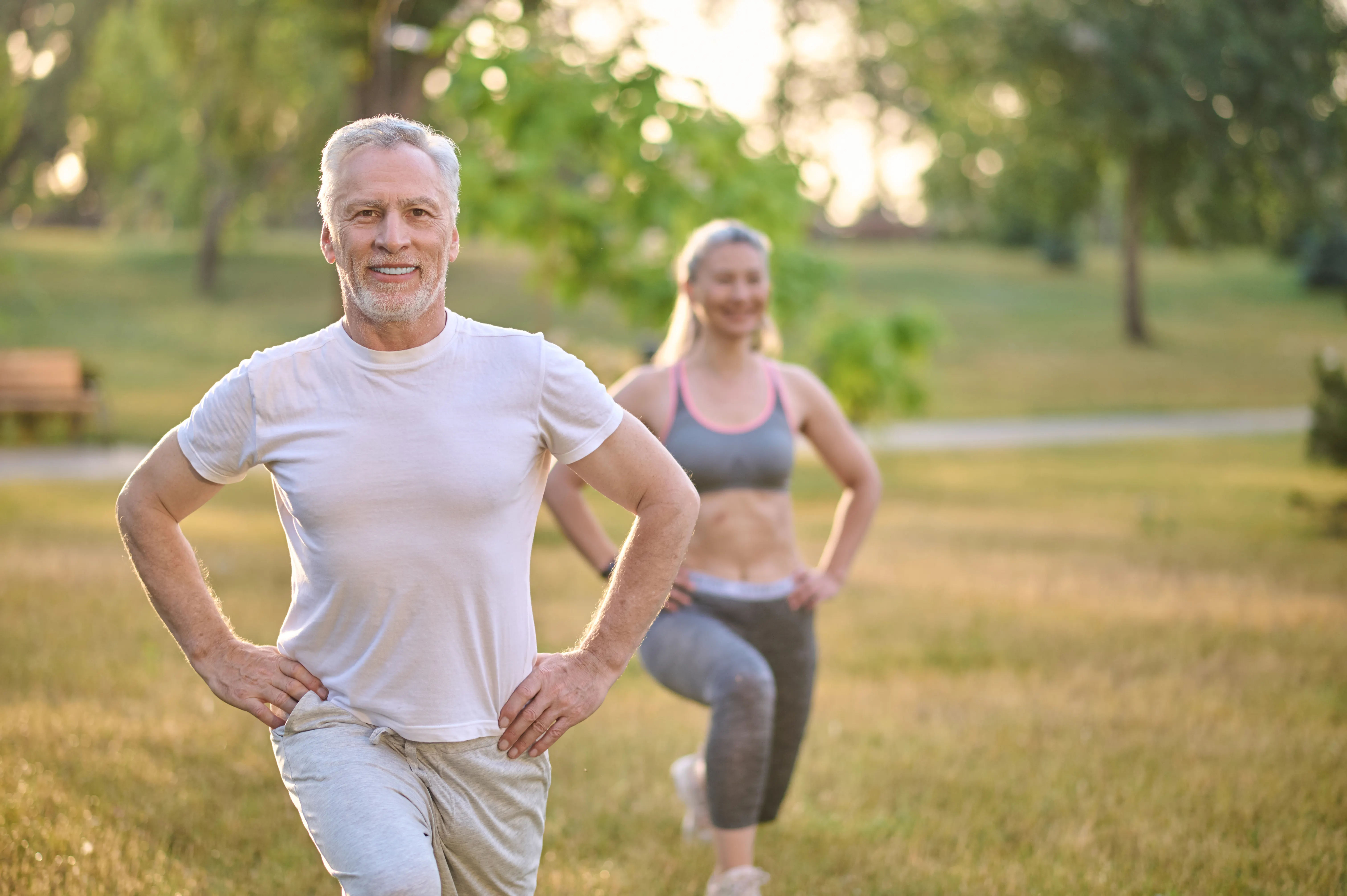 happy people stretching outside in park