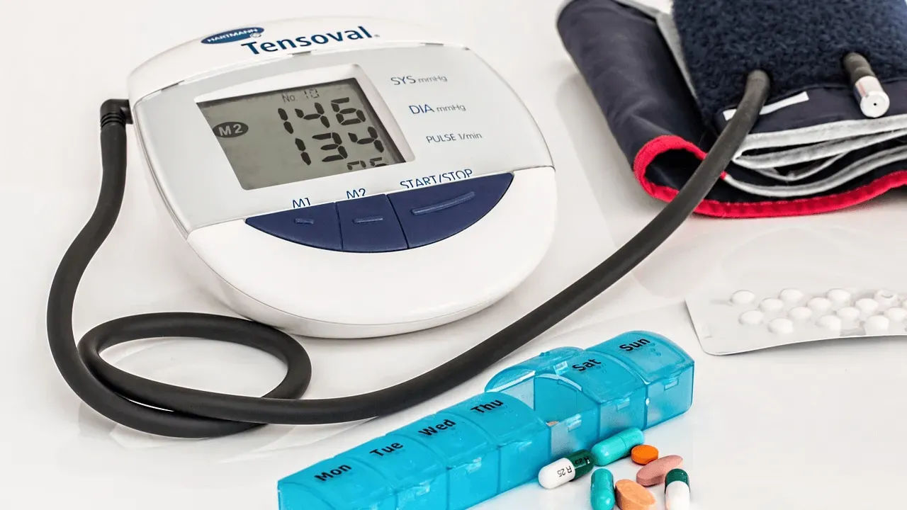 Image of a blood pressure machine and a blue pill box.