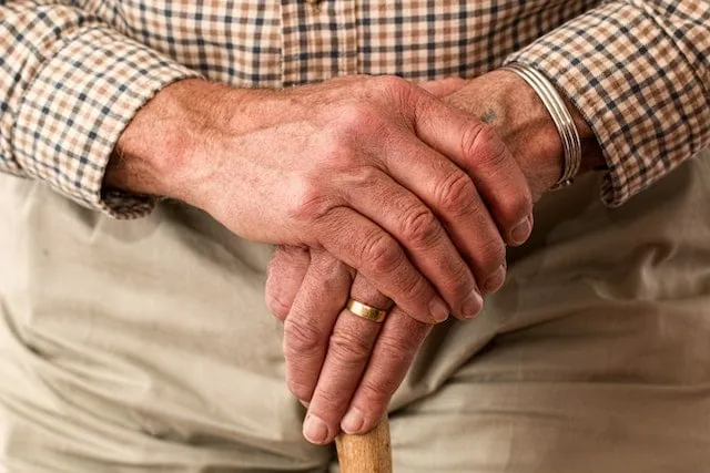 Hands resting on top of a cane