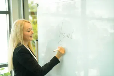 The Life Coaching Co Founder writes the word Vision on a whiteboard