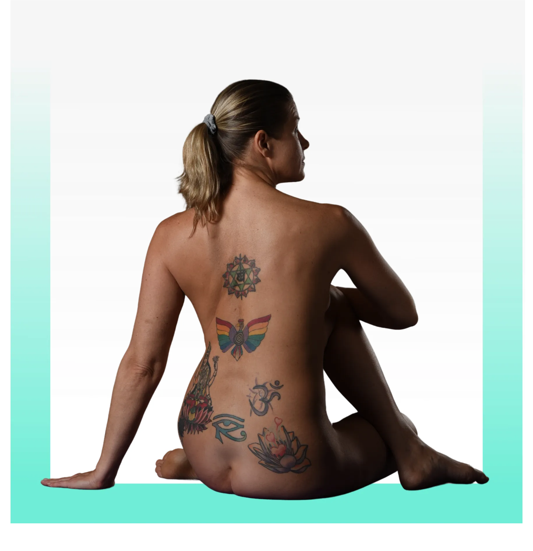 woman with tatoos her back toward viewer in a yoga pose