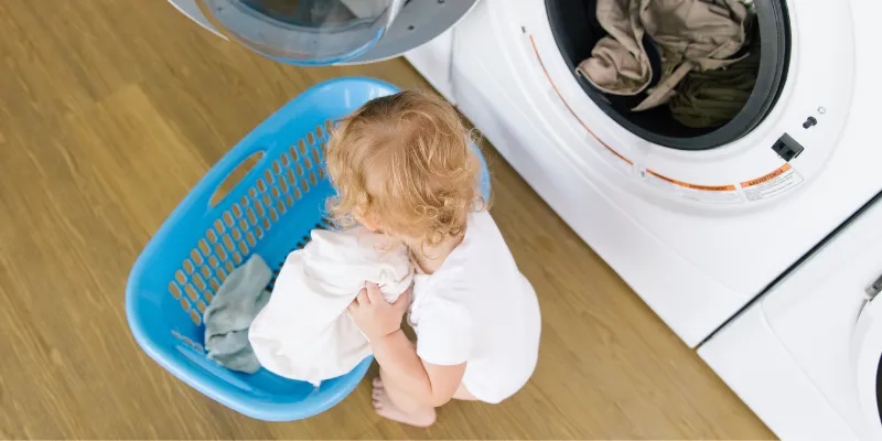 Little baby helping with laundry.