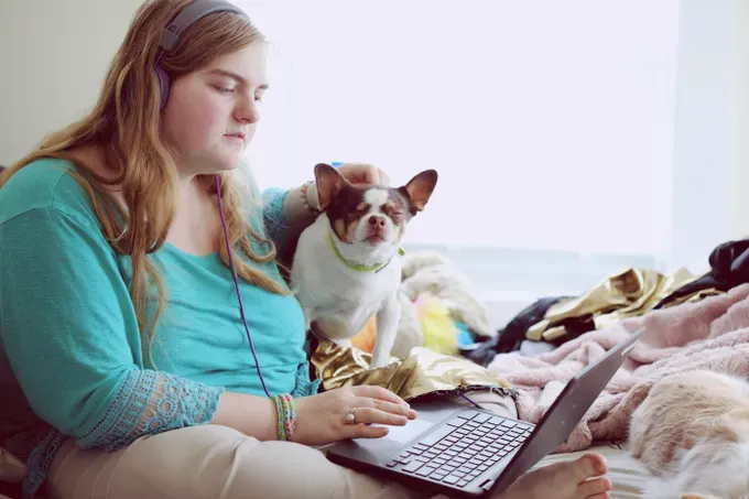 teen in front of computer with her dog