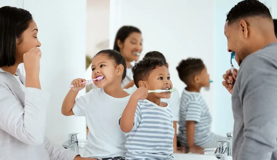 A positive and motivational image showing a family practicing good oral hygiene together.