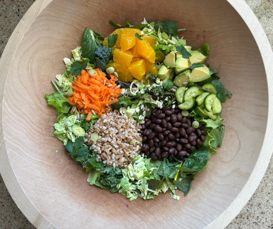 Finished citrus avocado winter salad with fresh greens, avocado, citrus, and toppings ready to serve