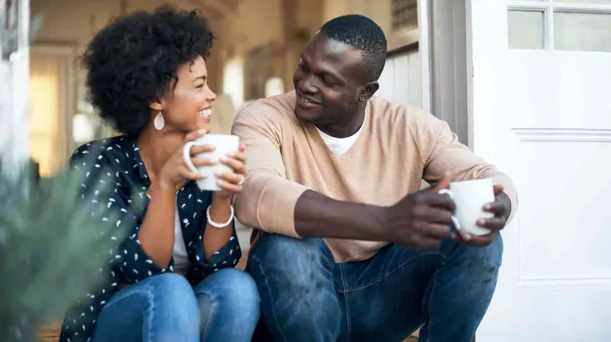 a couple having a deep conversation, perhaps over a cup of coffee, showing engagement and attentiveness. 