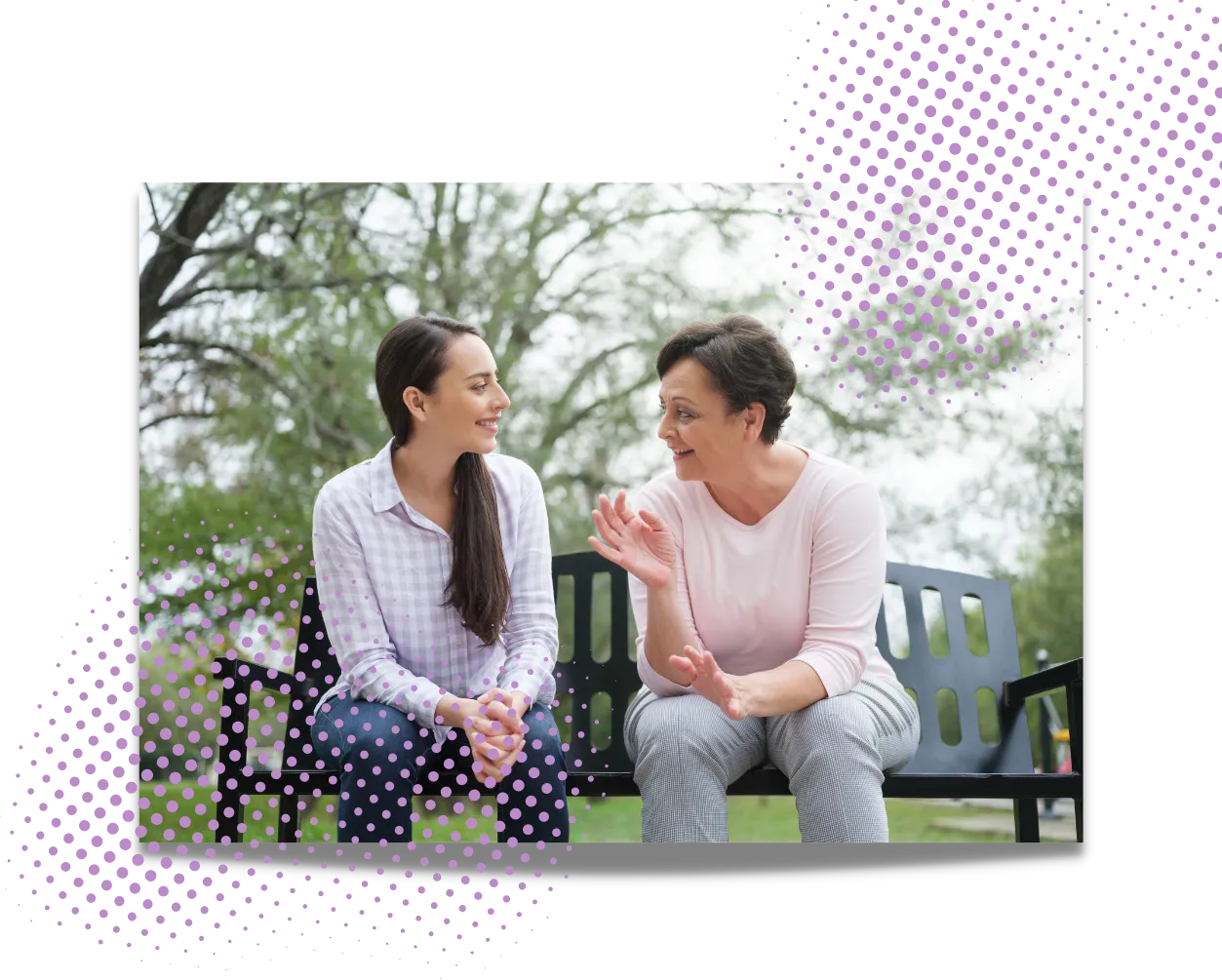 Two women sitting on a park bench talking