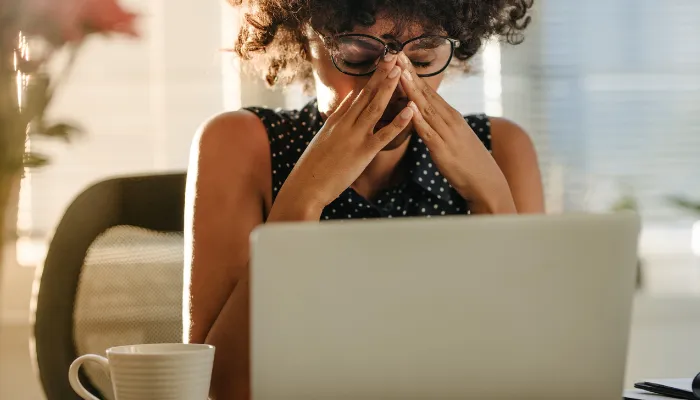 A mom stressed at her laptop.