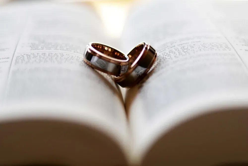 Two wedding rings in the centre of an open Bible