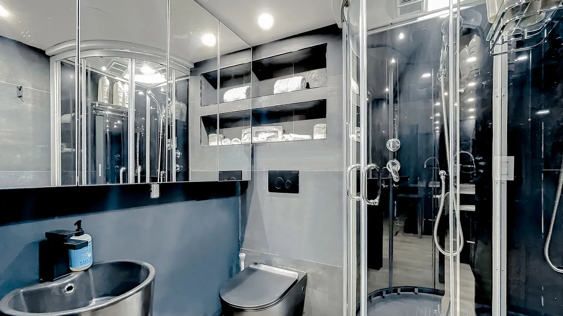 Modern bathrooms with dimmer lights, double sink vanities, shower, bath tub and double mirror wall cabinets