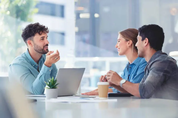 Real Estate Broker happily discussing real estate details to young couple 