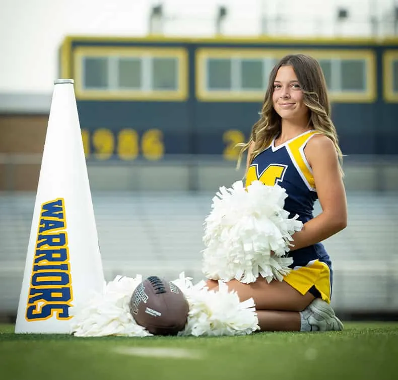 meridian high school cheerleader posing on the football field