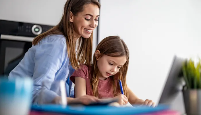 Mom helping her daughter with homework.