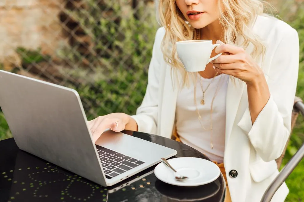 A women with coffee working on laptop